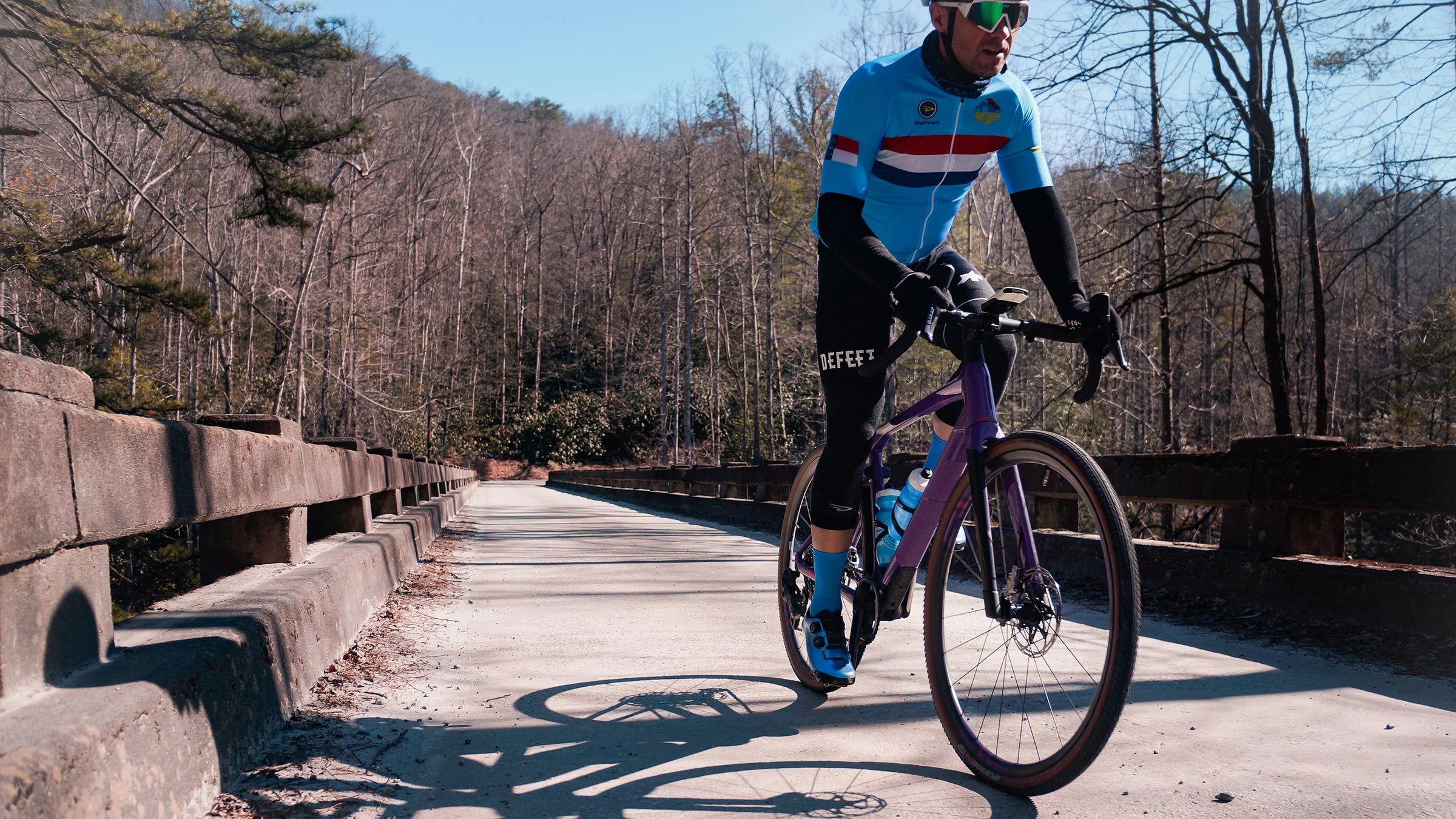 Cyclist wearing DeFeet cycling arm warmers & knee warmers