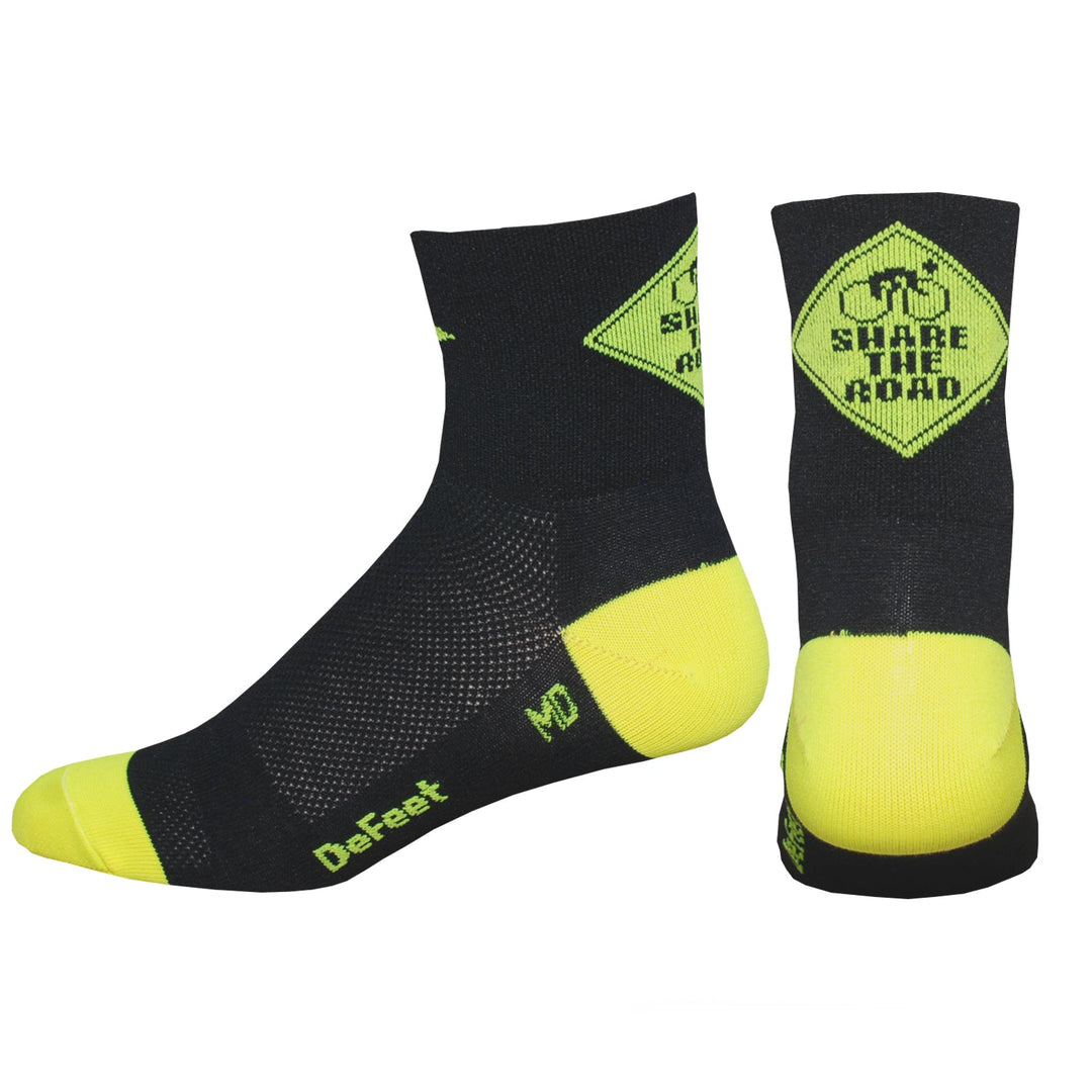 black cycling sock with a yellow heel and toe featuring a yellow caution sign on the back of the cuff with the words, "Share the Road."