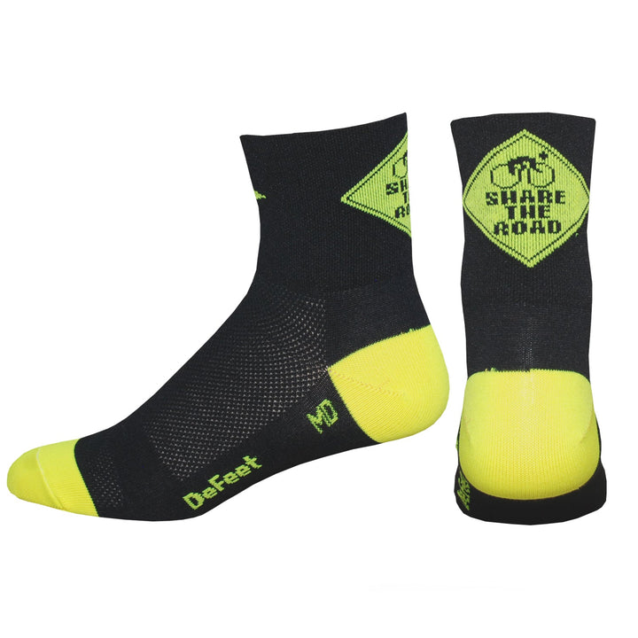 black cycling sock with a yellow heel and toe featuring a yellow caution sign on the back of the cuff with the words, "Share the Road."